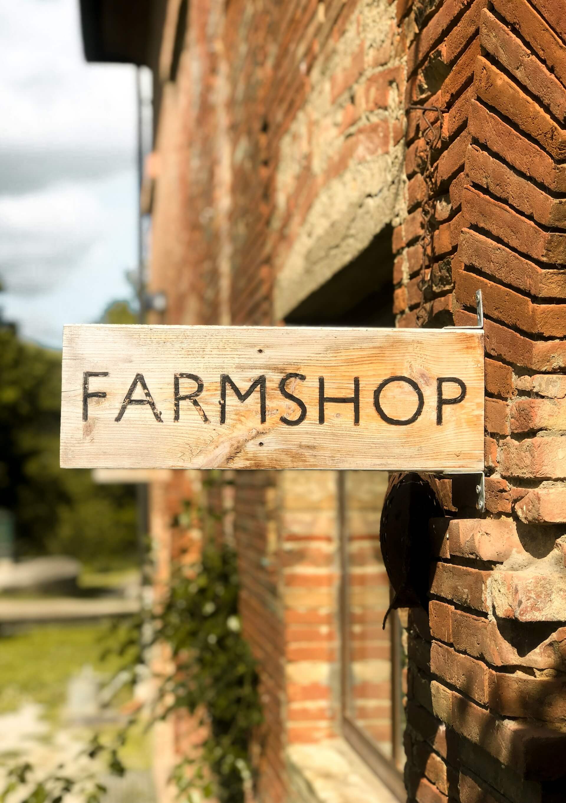 Image of wood farmshop sign attahced to building